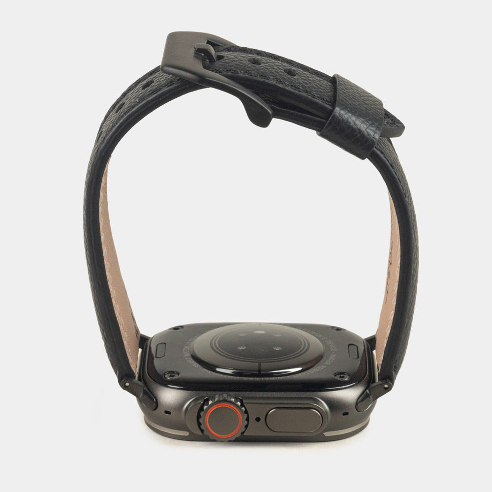 Apple Watch Ultra bandje heren 49 mm zwart Epsom leer met zwarte gespen — zijaanzicht, bandje open boven de kastbodem, welving en geverfde rand