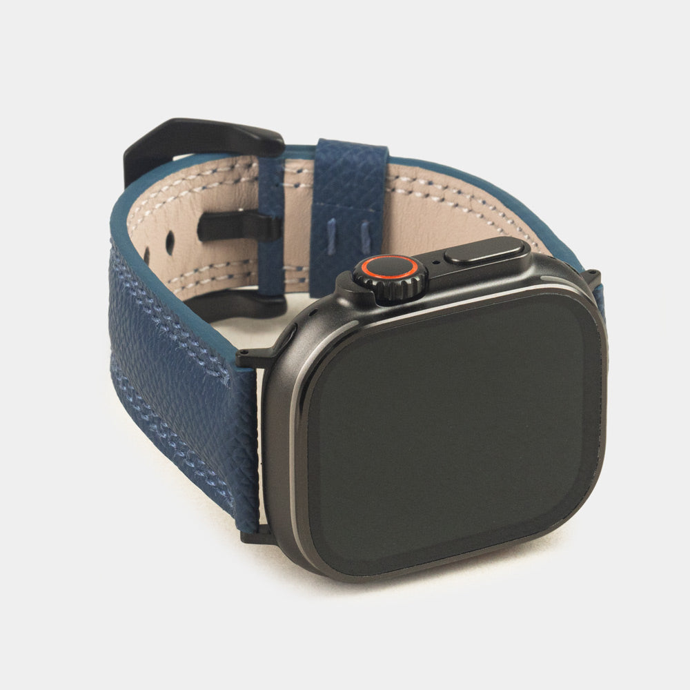Apple Watch Ultra bandje heren 49 mm blauw Epsom leer met zwarte gespen — driekwart vooraanzicht met de wijzerplaat van de Ultra, de gesp en de leren lus