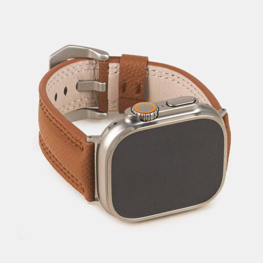 Apple Watch Ultra bandje heren 49 mm goud Epsom leer met titanium gespen — driekwart vooraanzicht met de wijzerplaat van de Ultra, de gesp en de leren lus