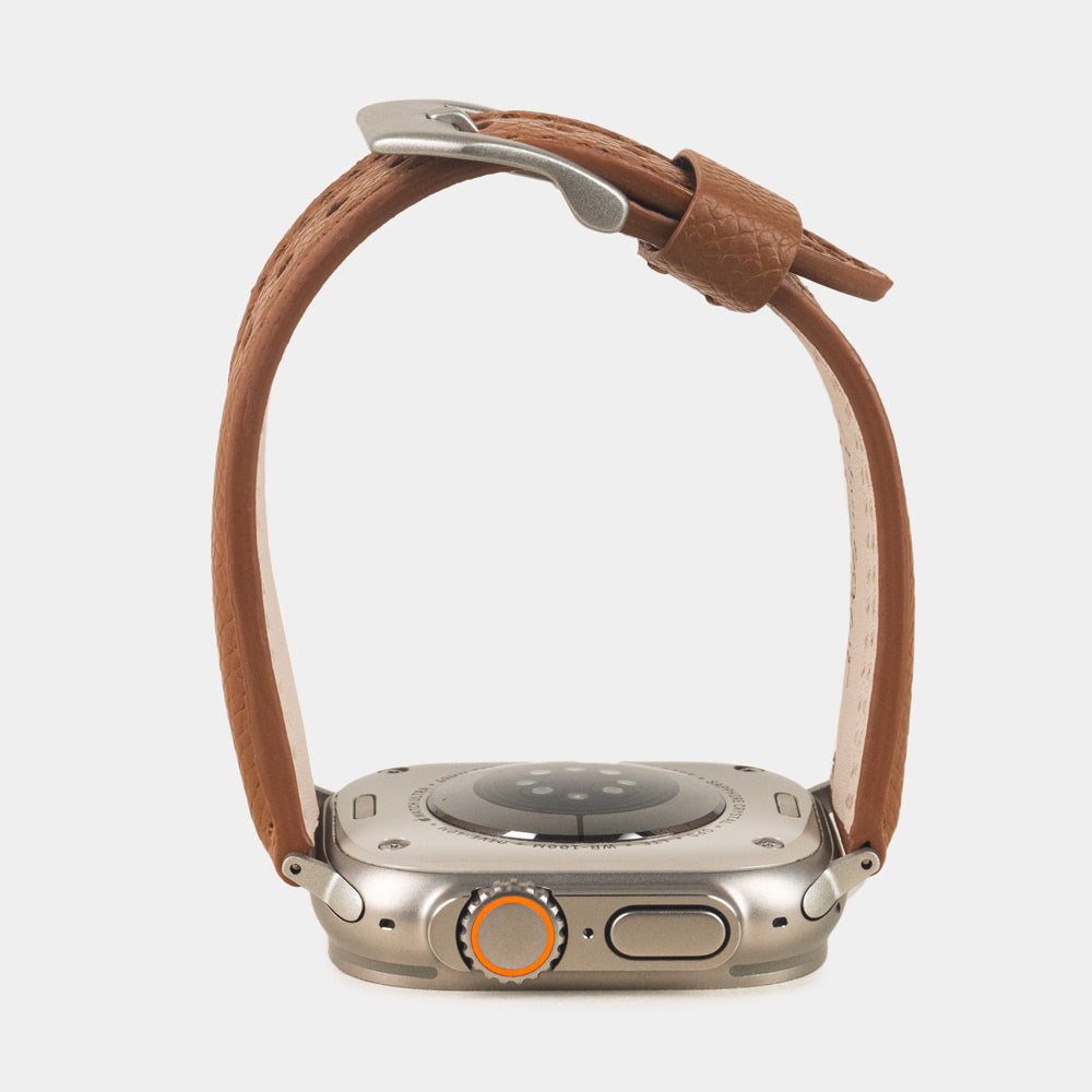 Apple Watch Ultra bandje heren 49 mm goud Epsom leer met titanium gespen — zijaanzicht, bandje open boven de kastbodem, welving en geverfde rand
