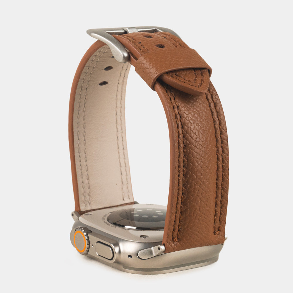 Apple Watch Ultra bandje heren 49 mm goud Epsom leer met titanium gespen — verhoogd driekwart achteraanzicht, crèmekleurige Alsavel voering en geverfde rand