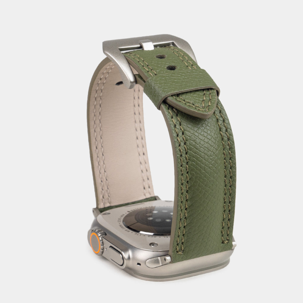 Apple Watch Ultra bandje heren 49 mm kakigroen Epsom leer met titanium gespen — verhoogd driekwart achteraanzicht, crèmekleurige Alsavel voering en geverfde rand