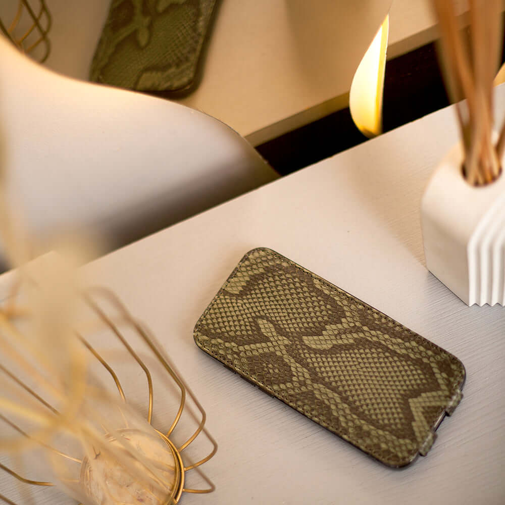 case iPhone 17 Pro Max python green on a stylish table with decor.