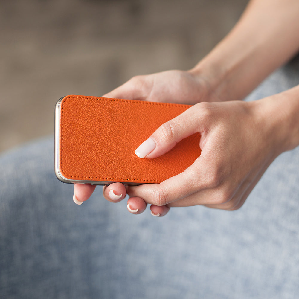 Orange leather flip case for iPhone X in woman's hand
