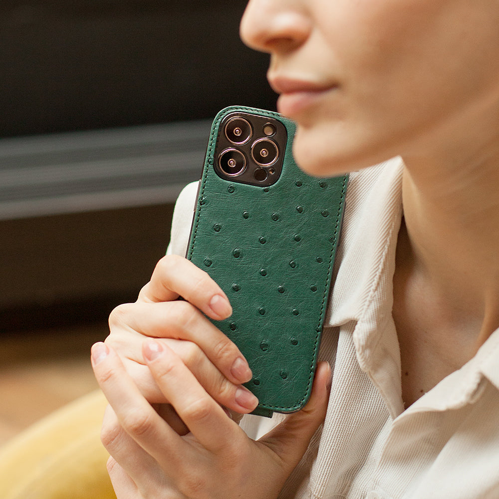 Woman holding iPhone 13 Pro with Marcel Robert green ostrich leather case showcasing the quill grain pattern