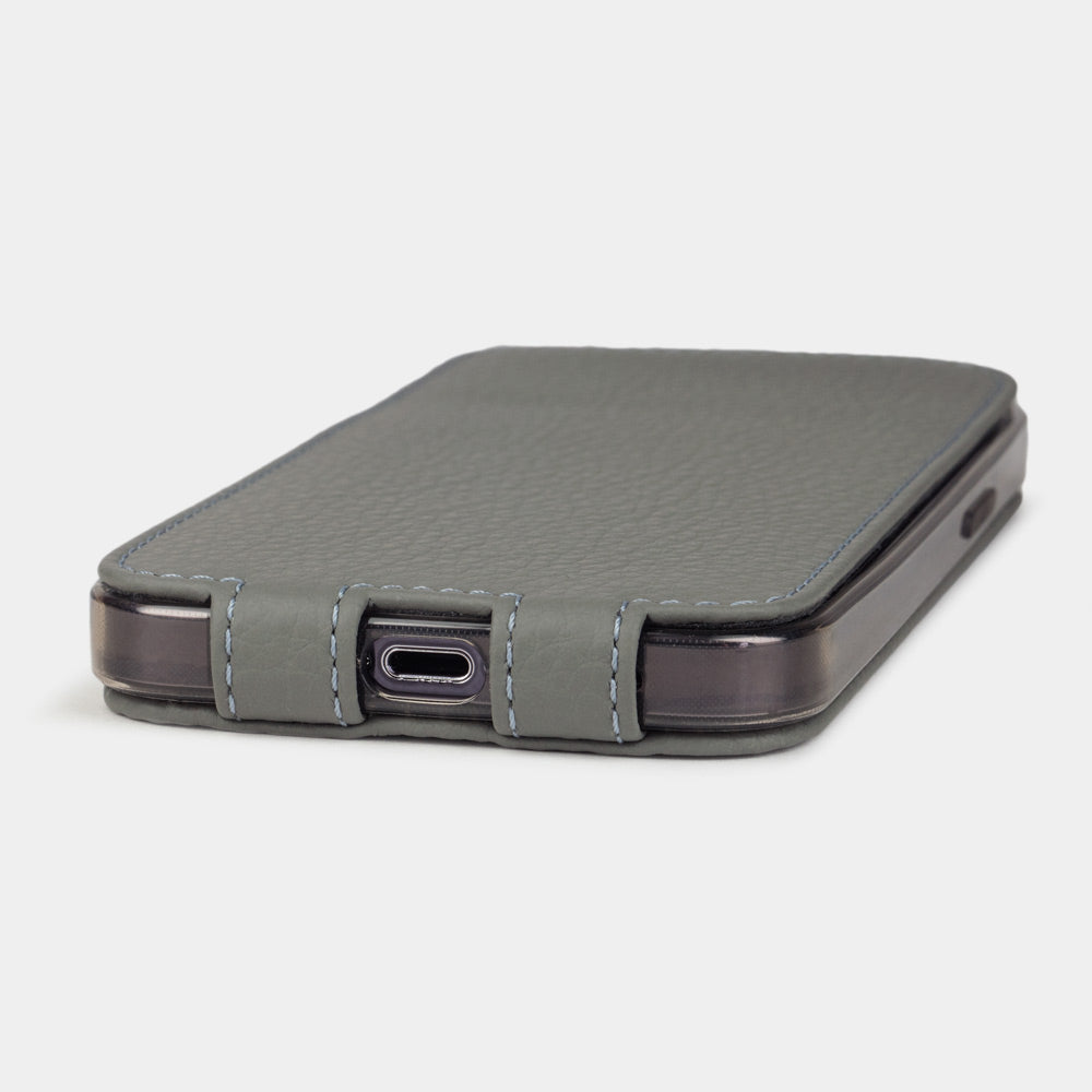 Grey calfskin leather flip case for iPhone 15 – bottom view with USB-C port opening and hand-stitched edges