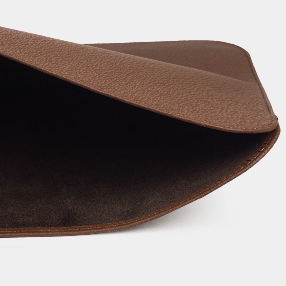 Leren laptophoes 14 inch in bruin, met MacBook deels erin geschoven — slanke minimalistische MacBook hoes