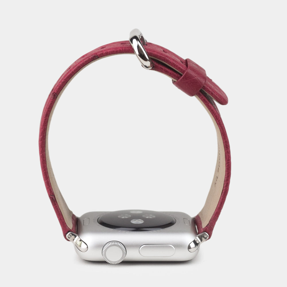 Strap for the Apple Watch 41/42 mm in fuchsia ostrich leather, with steel adapters and buckle | watch case on bottom to see leather texture, inner lining and the buckle