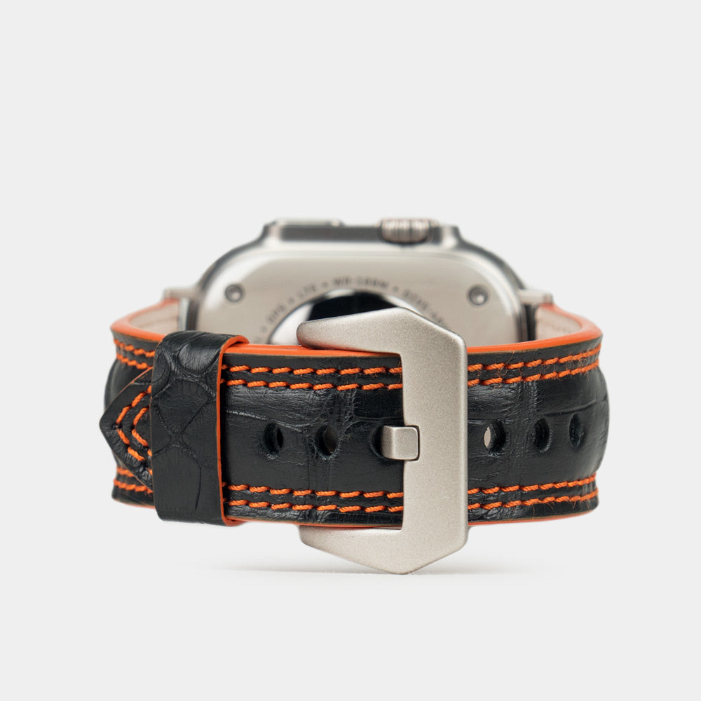 Apple Watch Ultra 49 mm aus schwarzem Alligatorleder, Naht und Kante in Orange, mit Adaptern und Schnalle aus Titan | Hauptbild