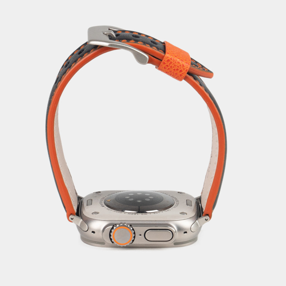 Correa de hombre para Apple Watch Ultra 49 mm en piel de becerro lisa negra con canto naranja y adaptadores en color titanio - vista del canto naranja de la correa