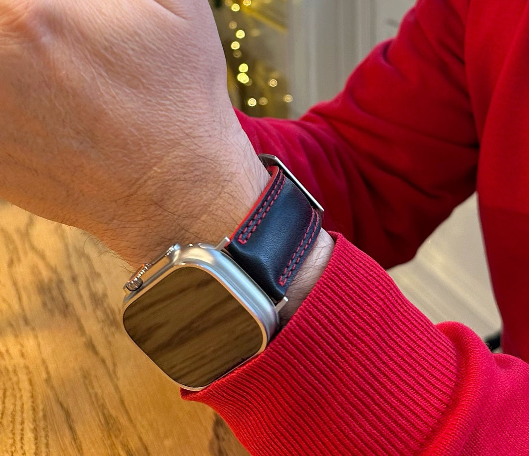 Correa de hombre para Apple Watch Ultra 49 mm en piel de becerro lisa negra con canto rojo y adaptadores en color titanio - vista en la muñeca
