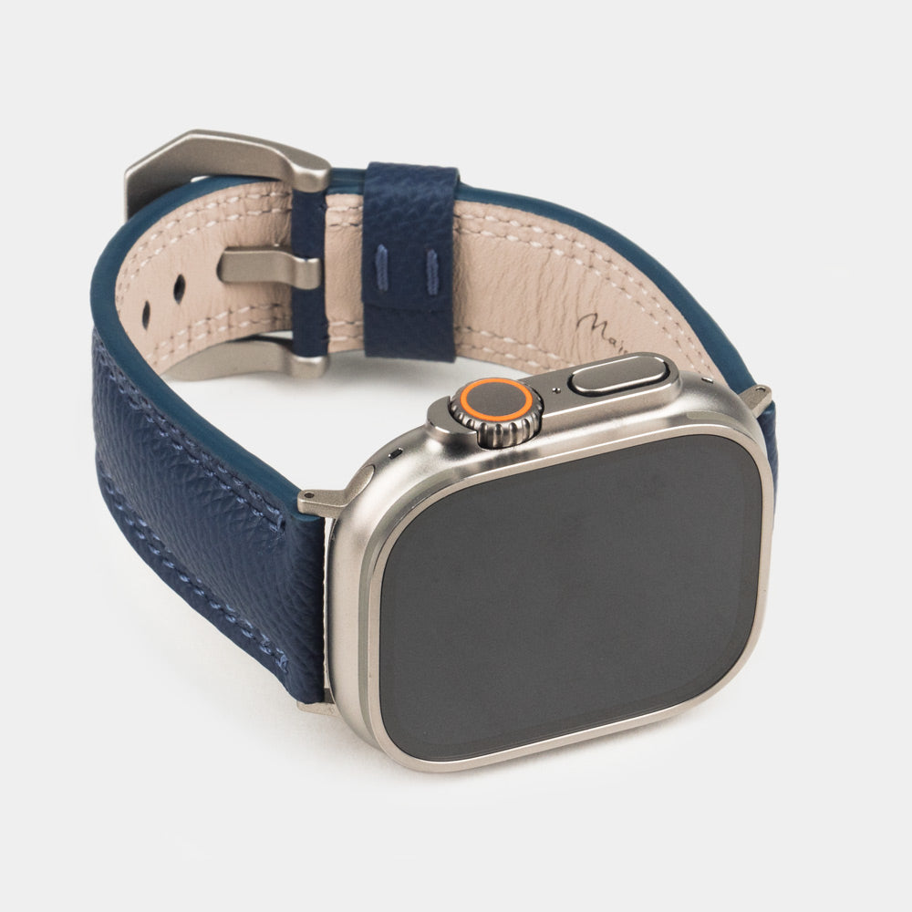 Apple Watch Ultra bandje heren 49 mm blauw Epsom leer — driekwart vooraanzicht met de wijzerplaat van de Ultra, de gesp en de leren lus