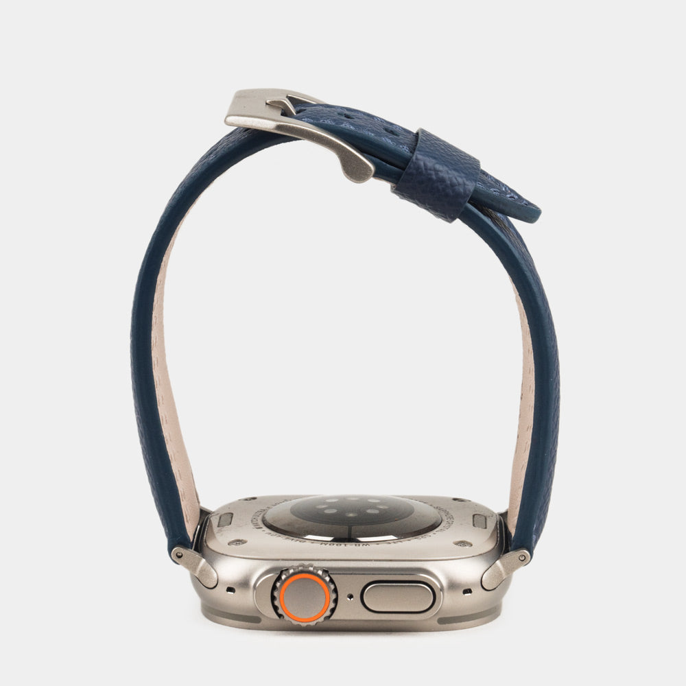 Apple Watch Ultra bandje heren 49 mm blauw Epsom leer — zijaanzicht, bandje open boven de kastbodem, met de welving en de geverfde rand