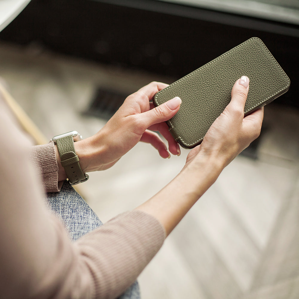 Leren flip-hoesje groen voor iPhone XS Max - in de handen van een vrouw, de klep wordt geopend