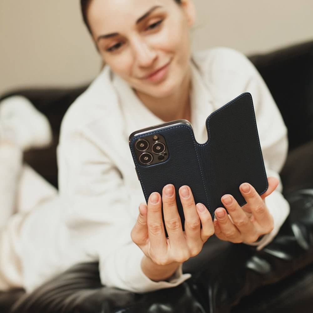 Woman holding a phone in blue wallet leather case