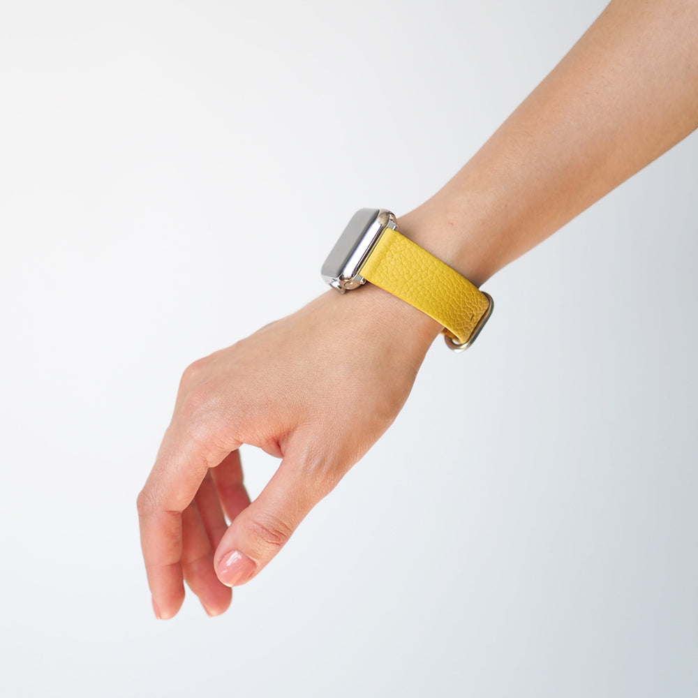Armband für die Apple Watch 41/42 mm aus weichem genarbtem Kalbsleder in Gelb, mit Adaptern und Schnalle aus Edelstahl | Lifestyle-Foto, das Armband am Handgelenk einer Frau getragen