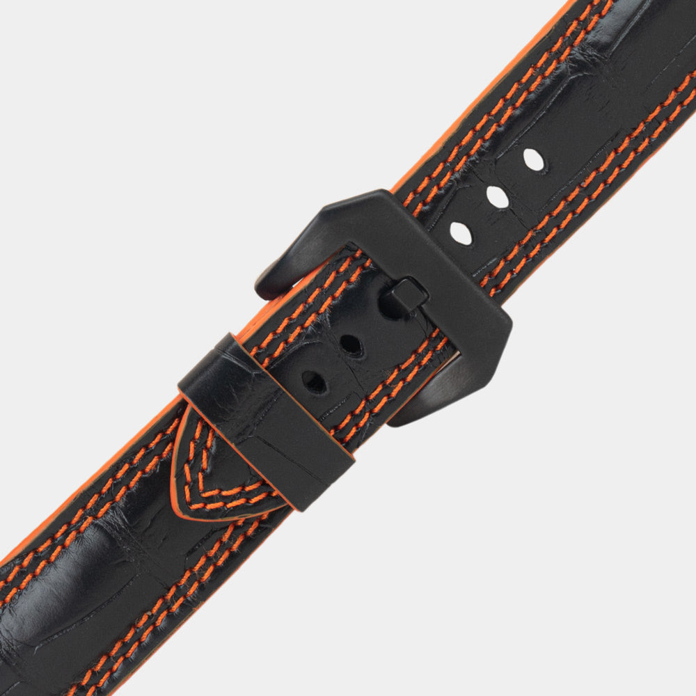 Apple Watch Ultra 49 mm aus schwarzem Alligatorleder, Naht und Kante in Orange, mit schwarzen Adaptern und Schnalle | Nahaufnahme der quadratischen Schuppen und der Doppelnaht in Orange