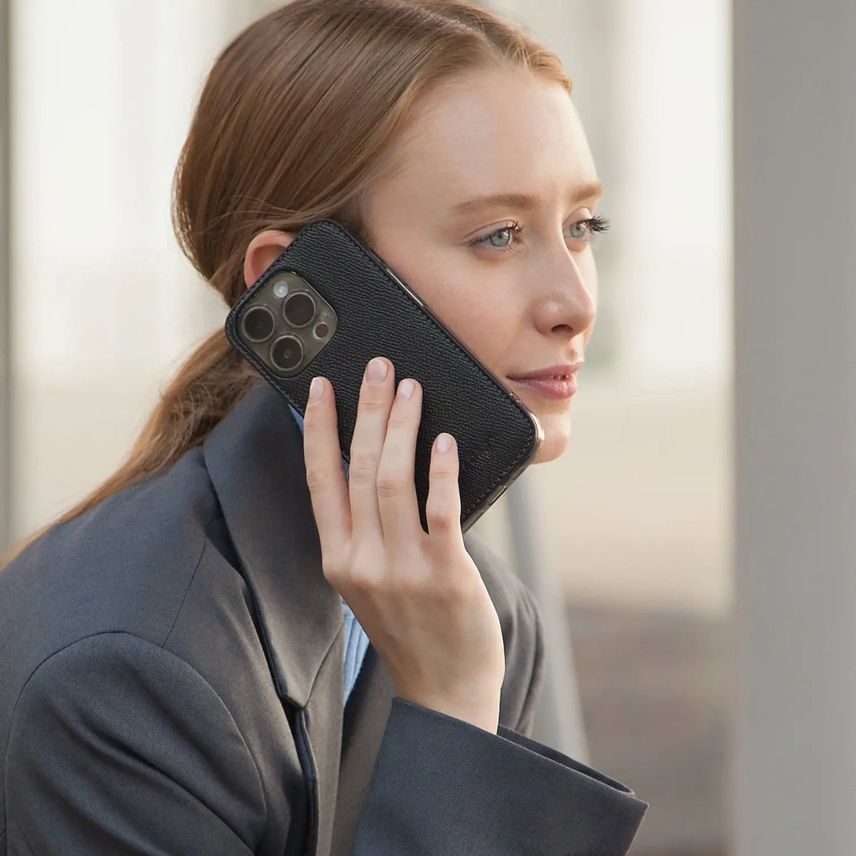 leather case Marcel Robert - a young woman is talking over the phone