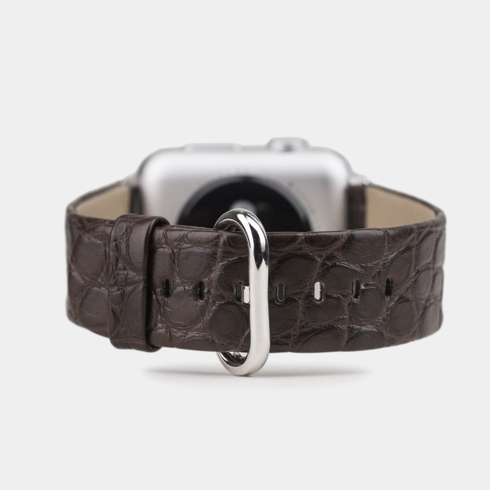 Dark brown alligator leather watch strap, attached to an Apple Watch, viewed from the back showing the clasp and textured strap