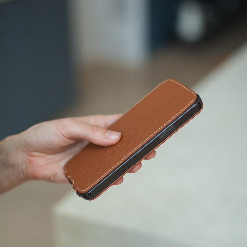 iPhone 13 Hülle aus goldfarbenem Kalbsleder in der Hand, Deckel geschlossen