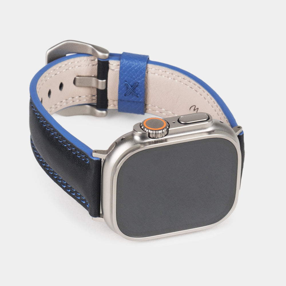 Bracelet homme Apple Watch Ultra 49 mm en cuir de veau lisse noir à tranche bleue et ses adaptateurs couleur titane - vue de face du cadran