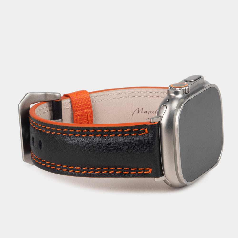 Bracelet homme Apple Watch Ultra 49 mm en cuir de veau lisse noir à tranche orange et ses adaptateurs couleur titane - vue de profil 3/4