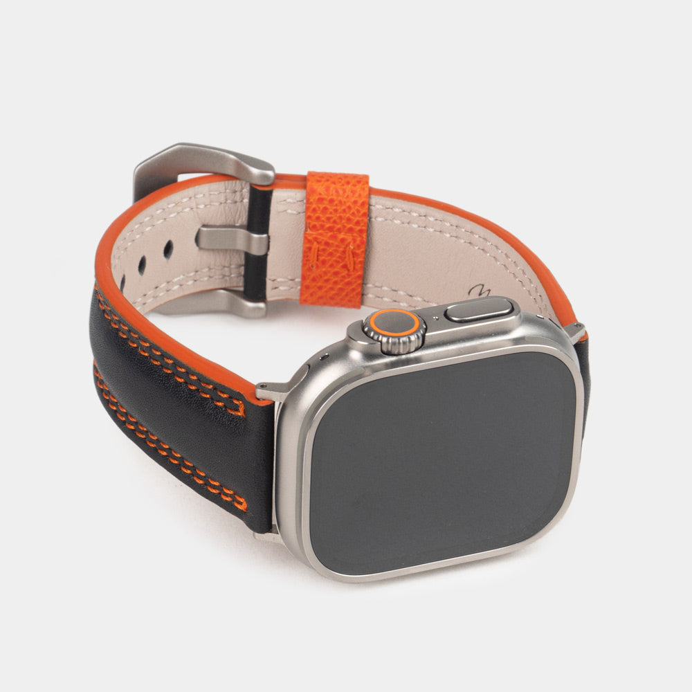 Bracelet homme Apple Watch Ultra 49 mm en cuir de veau lisse noir à tranche orange et ses adaptateurs couleur titane - vue de face du cadran