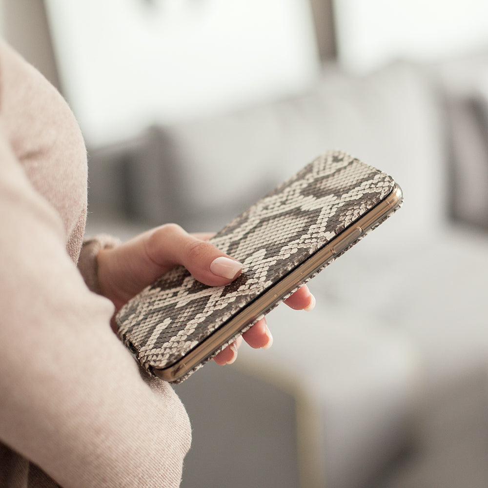Natural python leather flip case for iPhone 15 Pro held in one hand