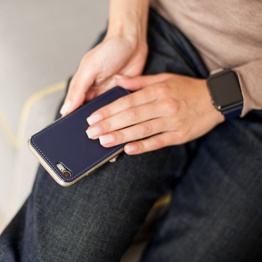 Funda de piel Azul Índigo para iPhone SE en las manos de una mujer, vista de cerca desde atrás