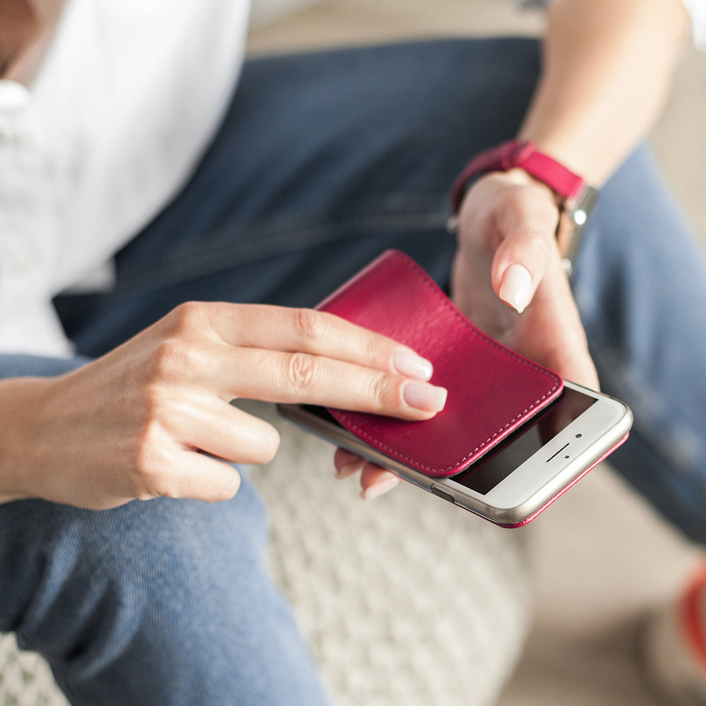 Funda de piel Fucsia para iPhone SE en las manos de una mujer