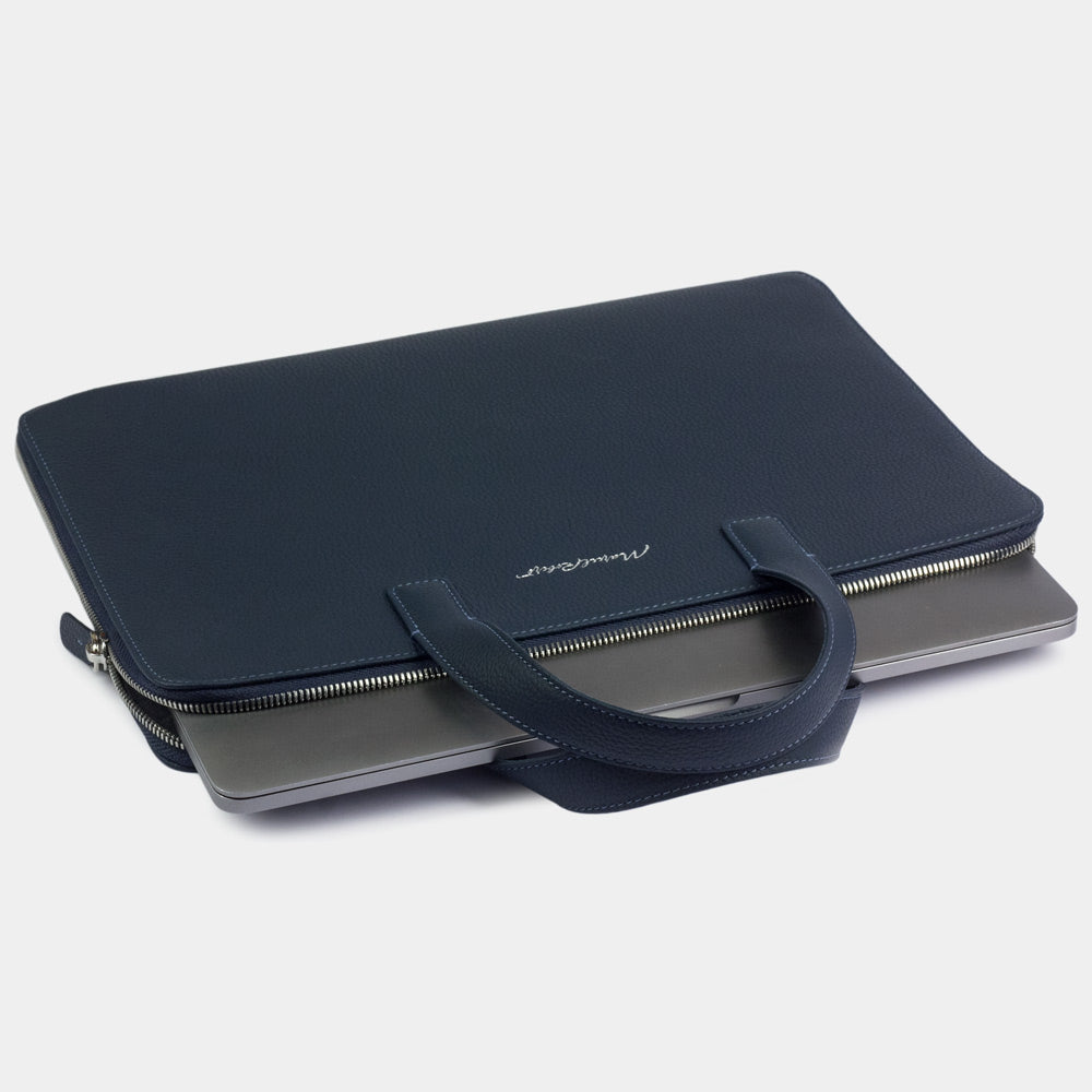 Slim 17 inch blue leather laptop bag holding laptop, structured minimalist design