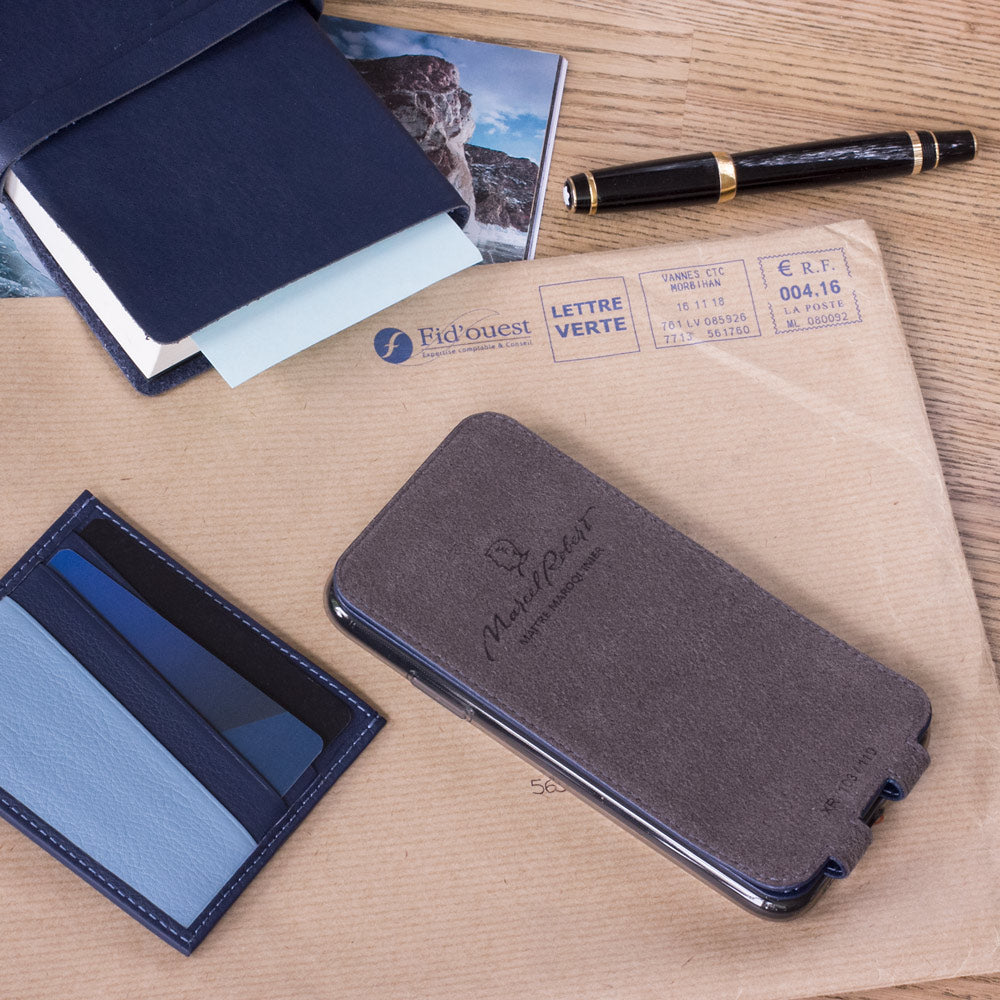Blue Indigo leather flip case for iPhone X - flat lay open showing the Alcantara interior, with a notebook, cardholder and pen