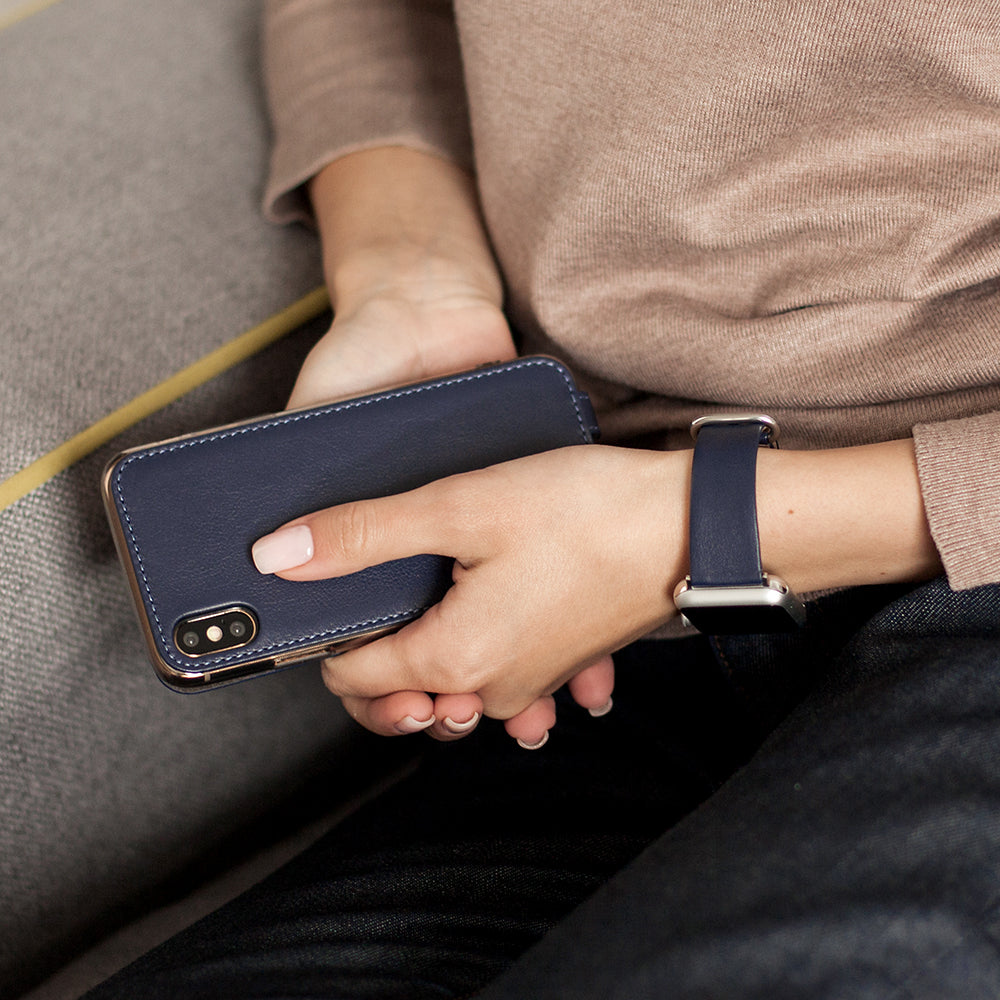 Blue Indigo leather flip case for iPhone X in woman's hand, resting on a cushion