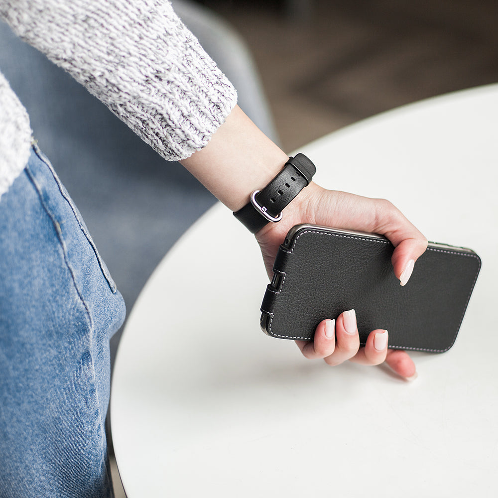 Leren flip-hoesje zwart voor iPhone XS Max - in de hand van een vrouw, zijaanzicht rustend op denim