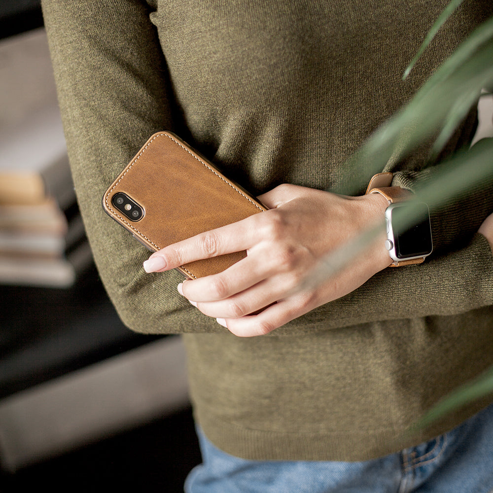 vintage leather flip case for iPhone X in woman's hand, held against her sweater