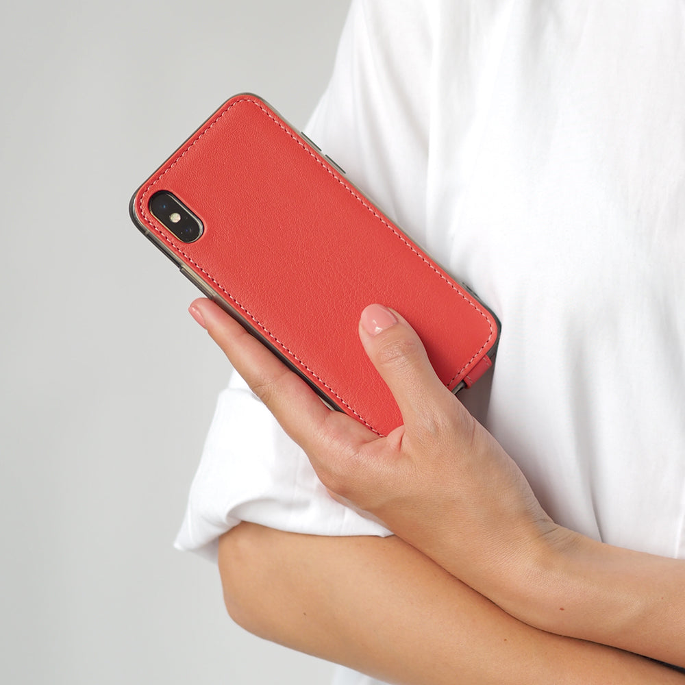 Red Coral leather flip case for iPhone X in woman's hand, held against her side