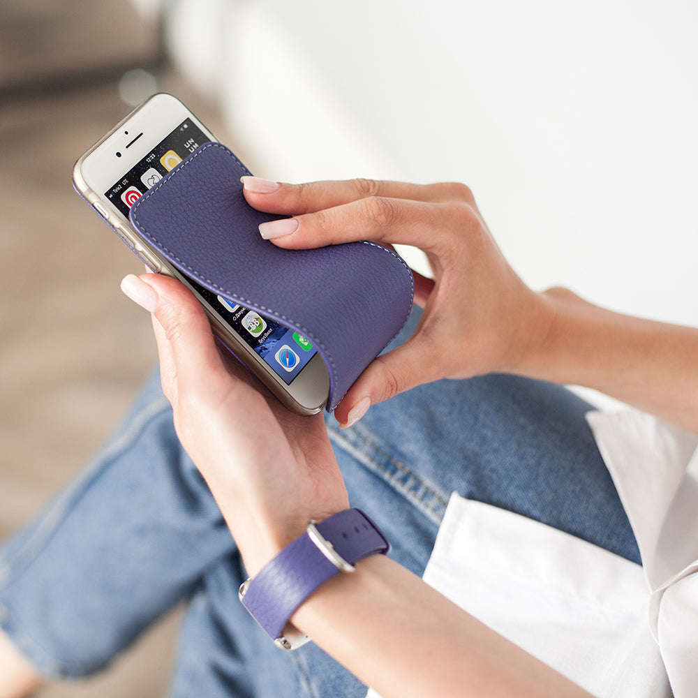Funda de piel Morado para iPhone SE en las manos de una mujer, abierta mientras se usa el teléfono