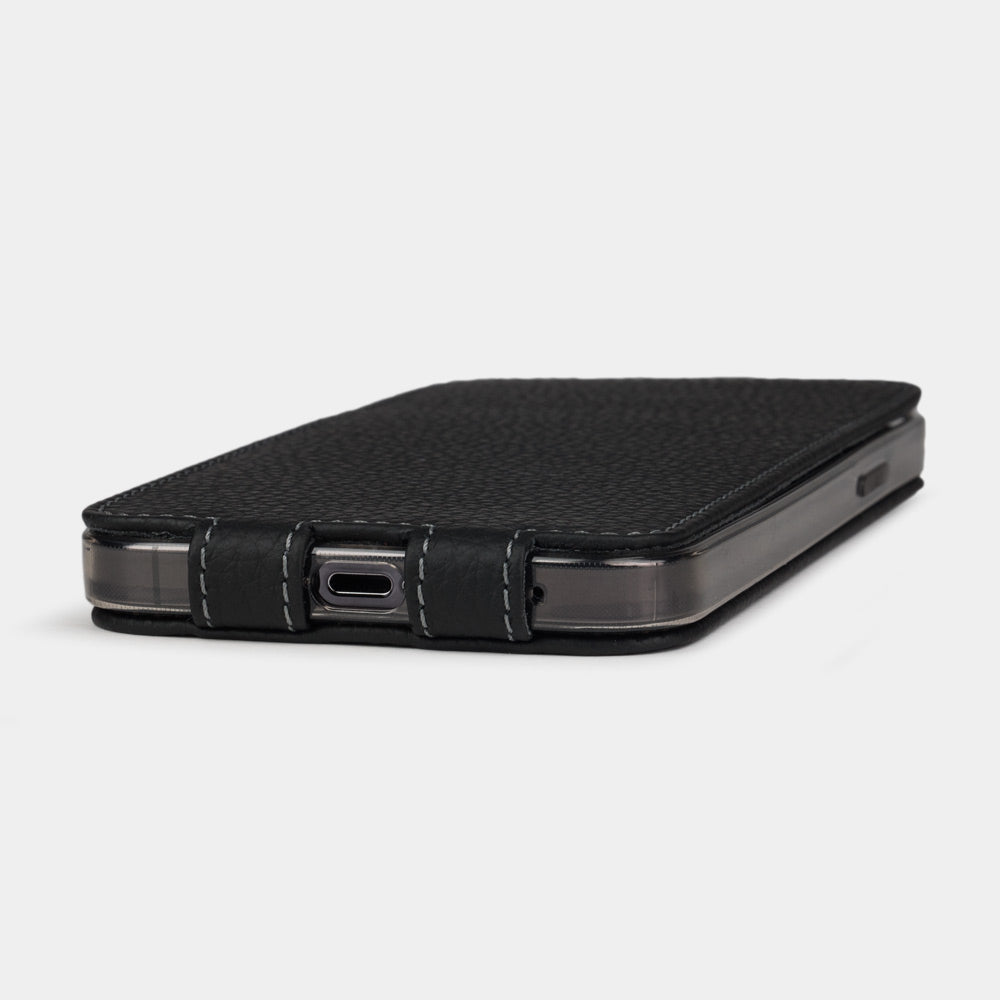 Black calfskin leather flip case for iPhone 15 – bottom view with USB-C port opening and hand-stitched edges