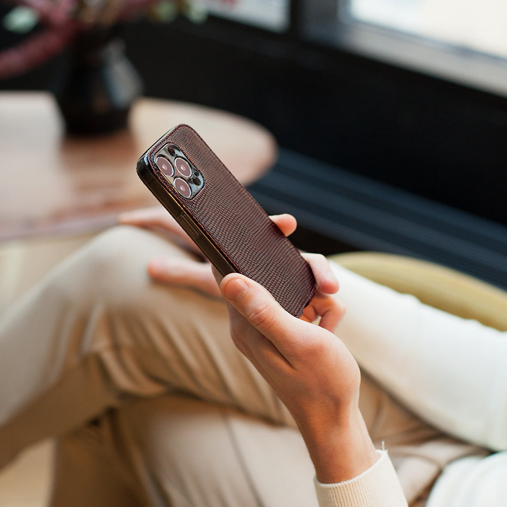 iPhone 14 Pro flip case in brown lizard leather – lifestyle photo: the case held in hand