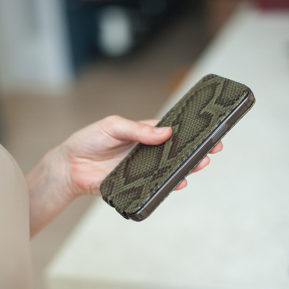 Green python leather flip case for iPhone 15 Pro held in one hand