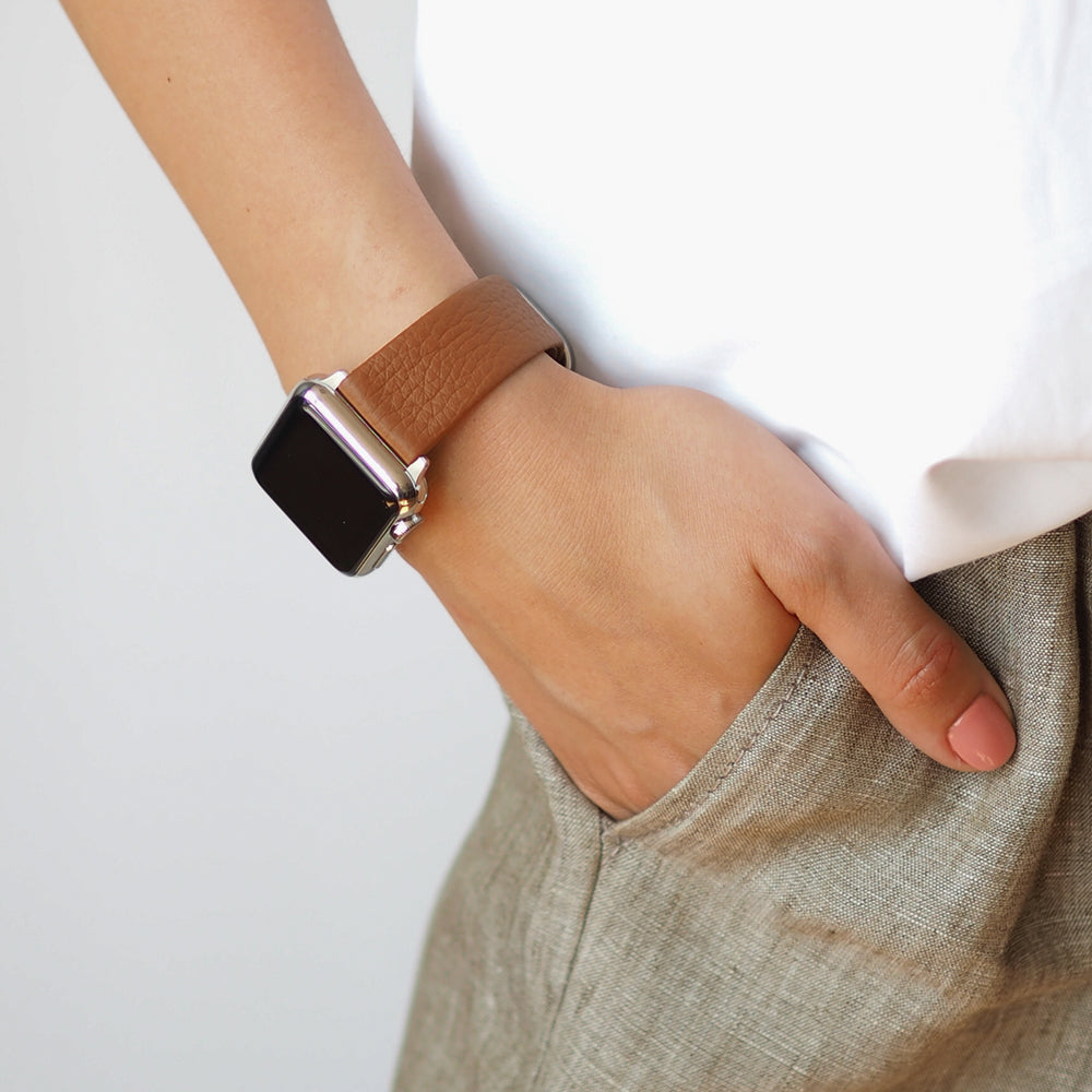 Armband für die Apple Watch 41/42 mm aus weichem genarbtem Kalbsleder in Gold, mit Adaptern und Schnalle aus Edelstahl | Lifestyle-Foto, das Armband am Handgelenk einer Frau getragen