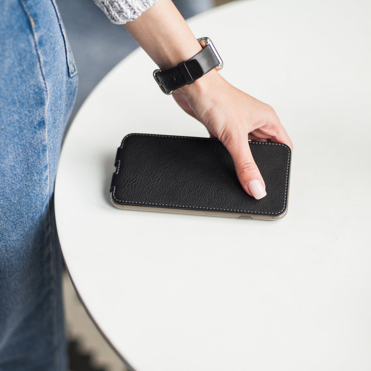 Armband für die Apple Watch 41/42 mm aus glattem Kalbsleder in Schwarz, mit Adaptern und Schnalle aus Edelstahl | Lifestyle-Foto, das Armband am Handgelenk einer Frau getragen