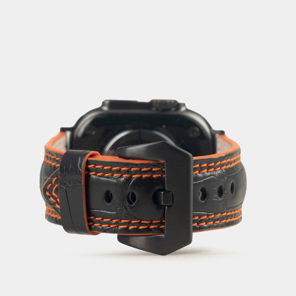 Apple Watch Ultra 49 mm aus schwarzem Alligatorleder, Naht und Kante in Orange, mit schwarzen Adaptern und Schnalle | Hauptbild
