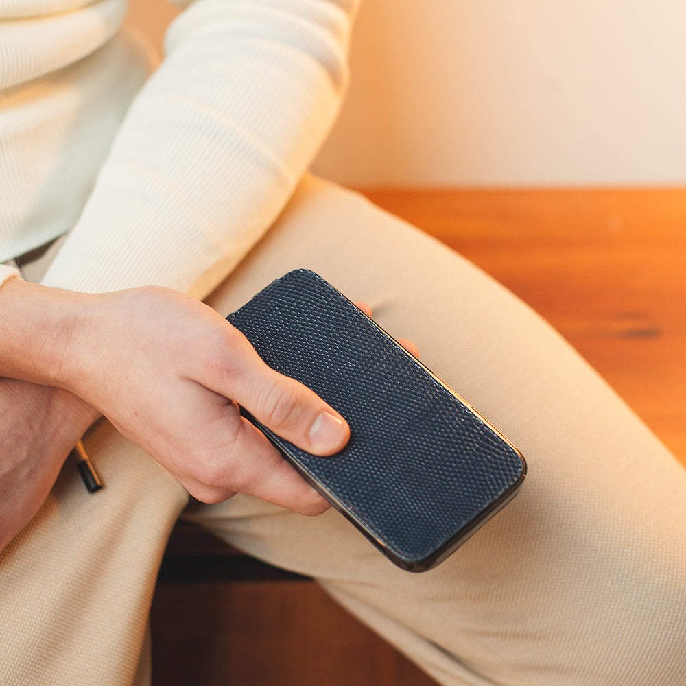 iPhone 14 Pro flip case in blue lizard leather – lifestyle photo: the case held in hand